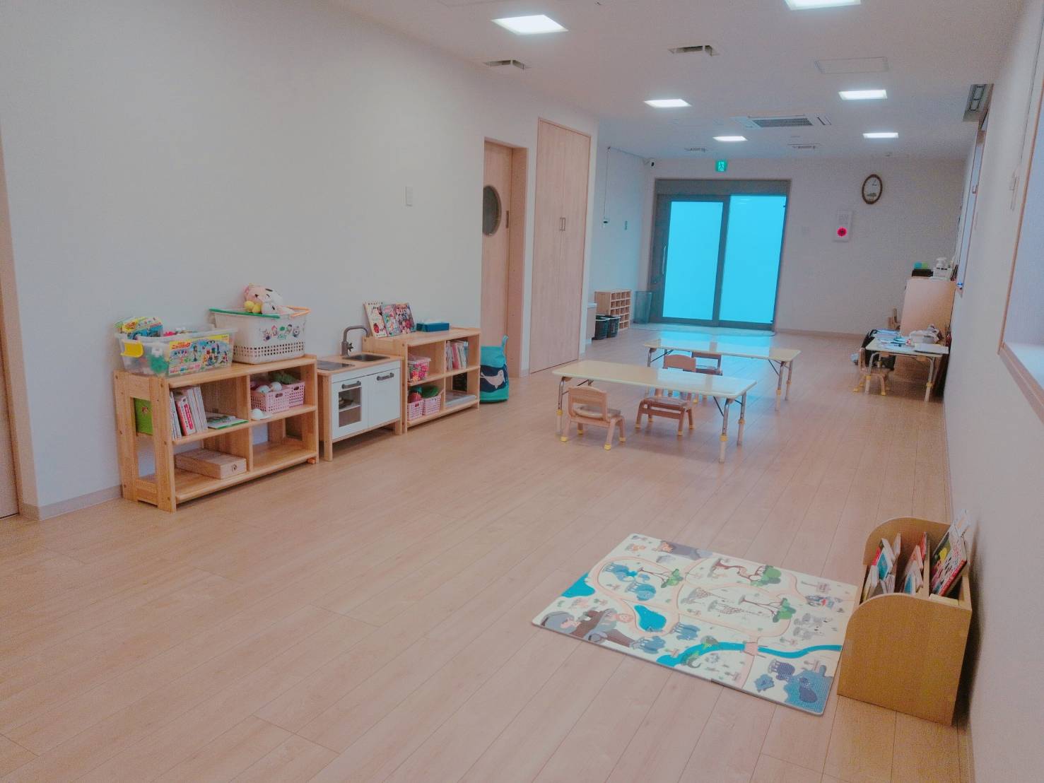 湘南ジュニアの室内。木の床と棚、机と椅子